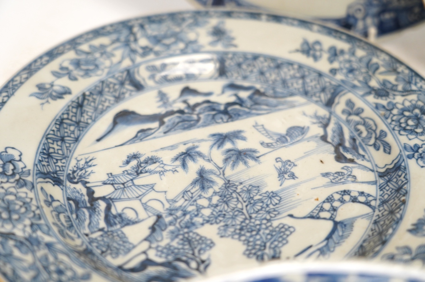Four Chinese blue and white export plates and a rice bowl, bowl 24.5cm diameter. Condition - poor to fair, some damage to the edges